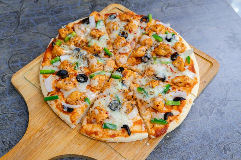 Homemade chicken pizza with olives and capsicum