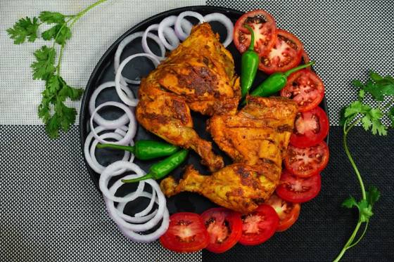 Spicy chicken tikka with onion rings and tomato slices